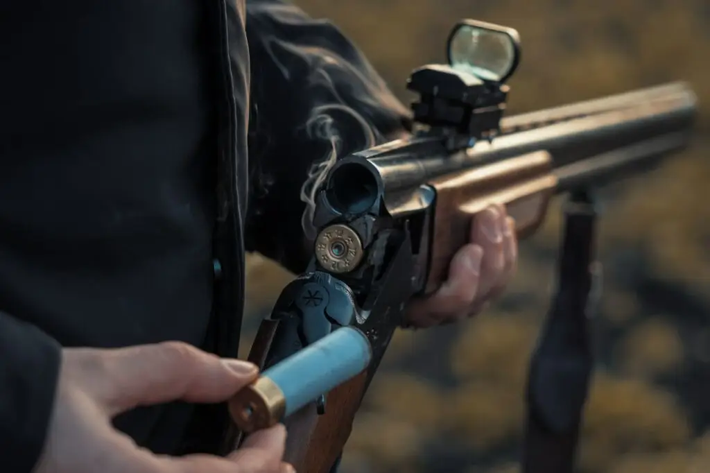 Sports shooting. Hunter reloading cartridge. Smoke from the trunks of smooth-bore hunting rifle