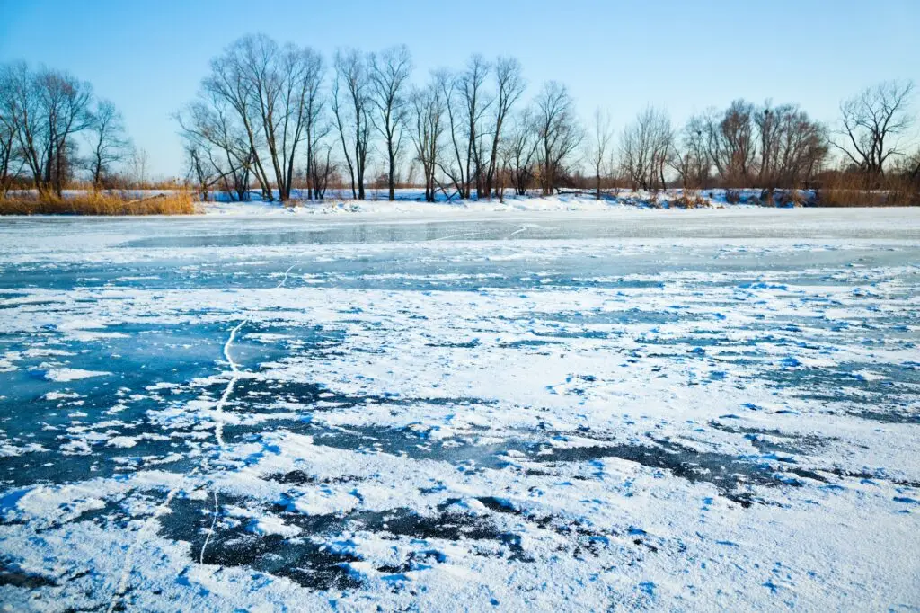 Winter frozen lake covered with ice and snow