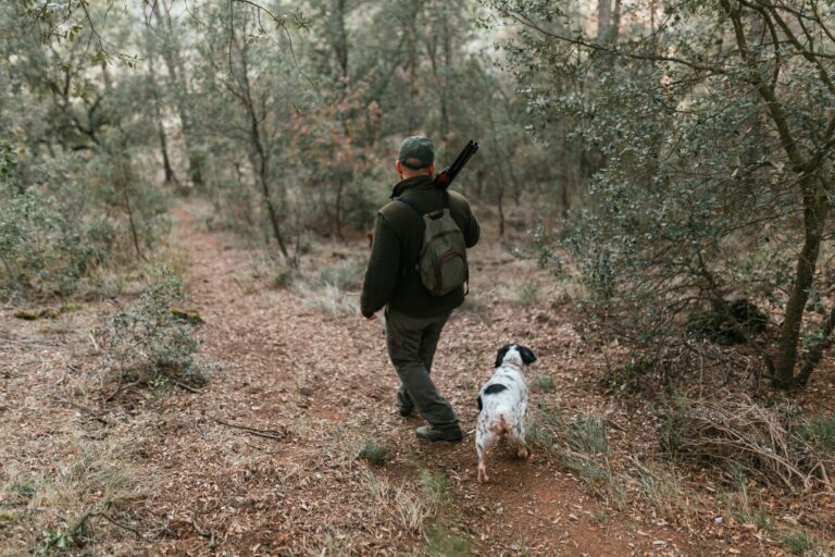 Man hunting with dog in dense forest
