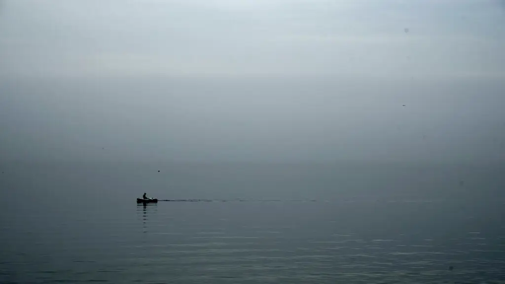 Row boat on gray foggy rainy morning day