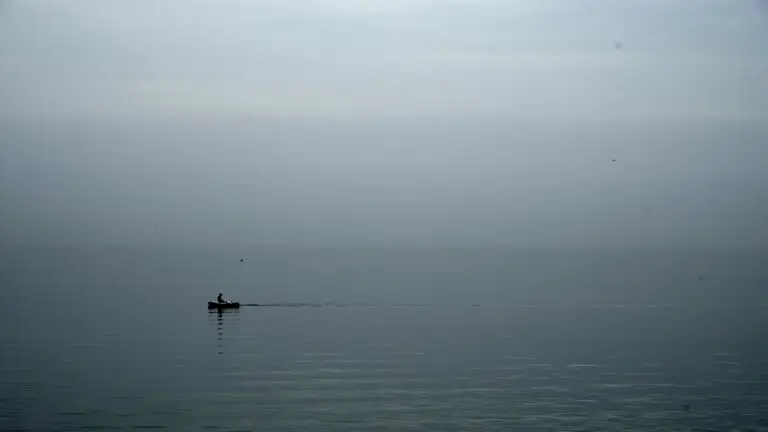 Row boat on gray foggy rainy morning day