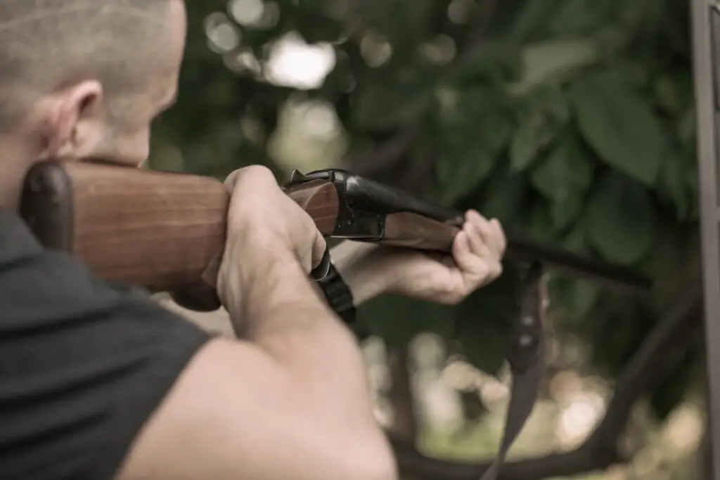Man charging double-barreled hunting rifle closeup