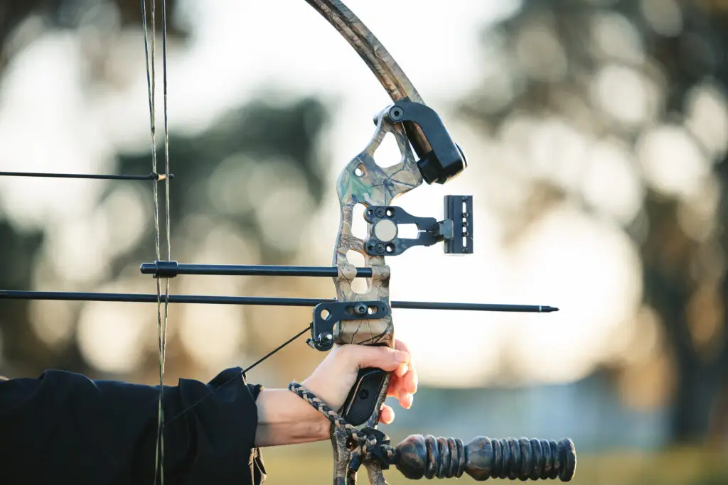 Archery bow closeup and woman hands at shooting range for competition, game or learning in field or